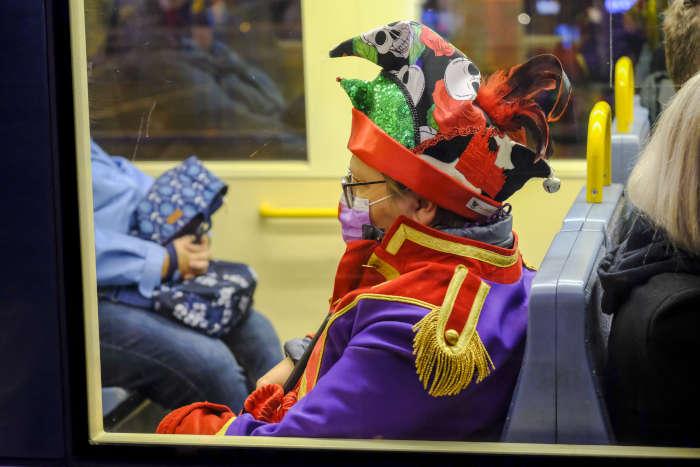Kostmierter Fahrgast mit Maske in der Stadtbahn