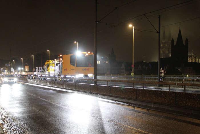 Gleisbauschienenfahrzeug fährt Nachts über die Deutzer Brücke