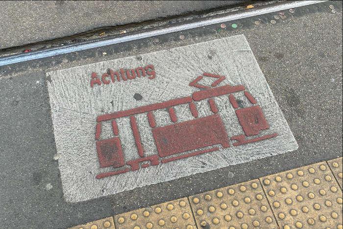 Piktogramm einer Stadtbahn als Warnhiweis auf dem Boden